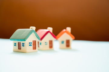 Colorful miniature house on brown background using as property and business concept
