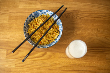 Asiatische Nudeln in Schale mit Milch und Stäbchen