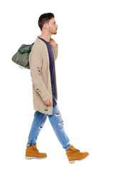 Naklejka premium back view of walking man with green bag.