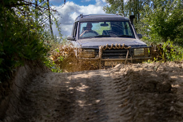 Obraz na płótnie Canvas SUV Sport Utility Vehicle with 4 x 4 off road on muddy track