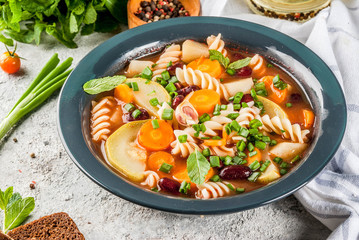 Italian vegetable soup Minestrone with fusilli pasta,  vegetarian food concept, dark rusty...