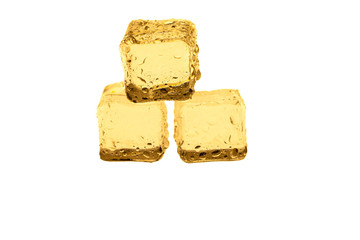 Golden ice cubes on white background.