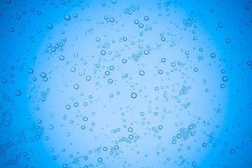 Rain droplets on blue glass background, Water drops on glass.