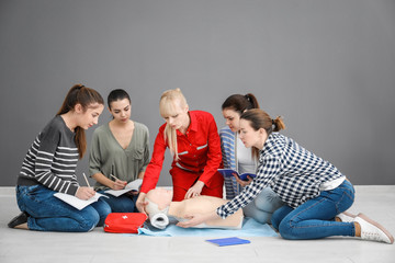 Group of people practicing CPR on mannequin at first aid class