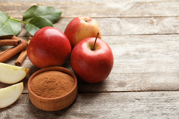 Fresh apples with cinnamon sticks and powder on wooden table © New Africa