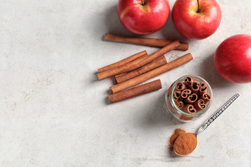 Fresh apples with cinnamon sticks and powder on table, top view
