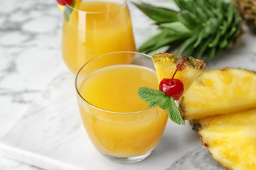 Glasses with delicious pineapple juice on table