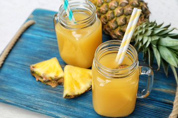 Mason jars with delicious pineapple juice on tray