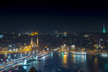 Fototapeta na wymiar Long exposure cityscape of Istanbul at a night. Galata bridge on Golden Horn gulf. Wonderful romantic old town at Sea of Marmara. Bright light of street lighting and various ships. Istanbul. Turkey.