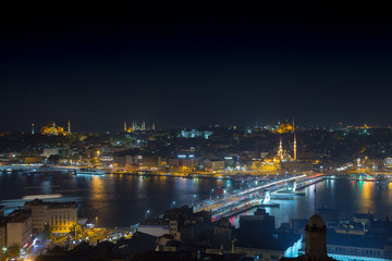 Long exposure cityscape of Istanbul at a night. Galata bridge on Golden Horn gulf. Wonderful romantic old town at Sea of Marmara. Bright light of street lighting and various ships. Istanbul. Turkey.