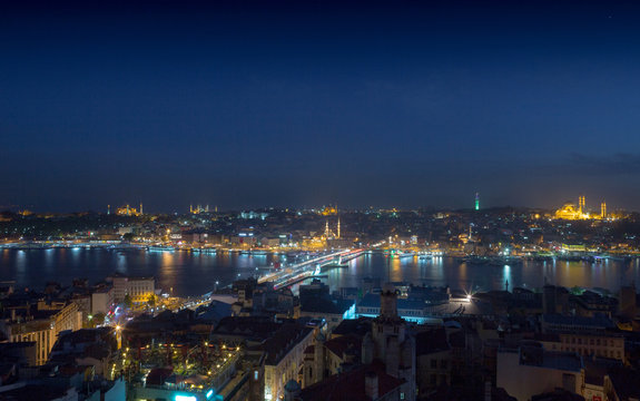 Long exposure cityscape of Istanbul at a night. Galata bridge on Golden Horn gulf. Wonderful romantic old town at Sea of Marmara. Bright light of street lighting and various ships. Istanbul. Turkey.
