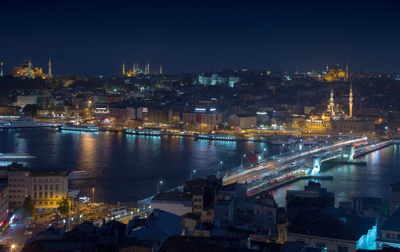Long exposure cityscape of Istanbul at a night. Galata bridge on Golden Horn gulf. Wonderful romantic old town at Sea of Marmara. Bright light of street lighting and various ships. Istanbul. Turkey.