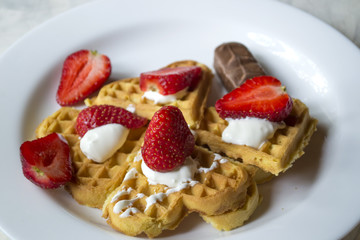 Ripe strawberry on waffles close up. Beautiful and tasty breakfast.