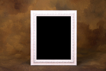 white vintage frame on wooden table over gold background