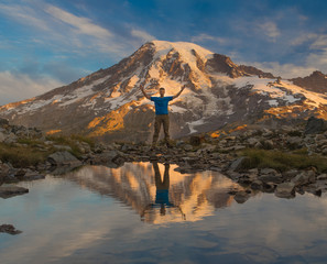 Hiker and Mt. Rainier reflecting in lake
