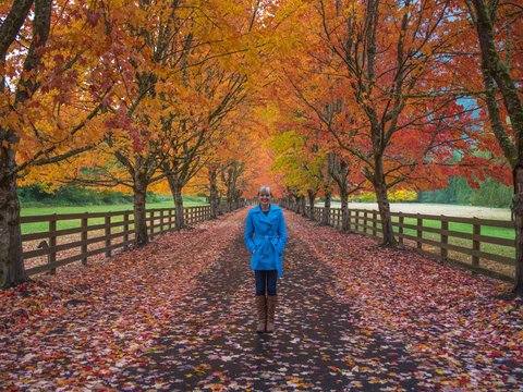 Woman enjoying fall colors in road