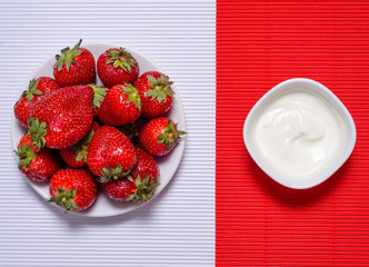 Strawberry on plate cream on red white background