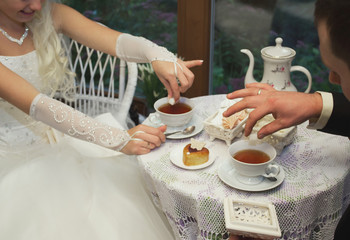 Newlyweds drink tea at a table in a cafe