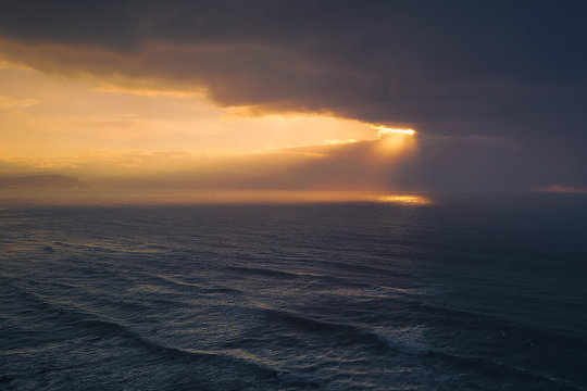 seascape with golden sun rays and stormy clouds © mimadeo