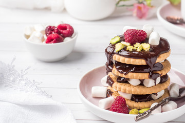 A sweet dessert of a chocolate cookie raspberry and marshmallow