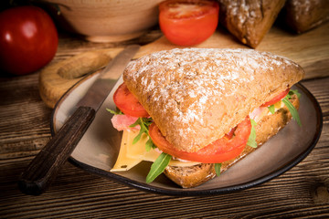 Triangular sandwich with cheese, ham and tomato.