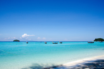 Fototapeta na wymiar Turquoise sea And blue sky White Sand Beach with taxi long tail boat, travel concept. Koh Lipe, Satun, Thailand