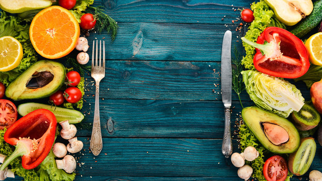 Assortment of fresh vegetables and fruits. Healthy food On a blue wooden background. Top view. Copy space.