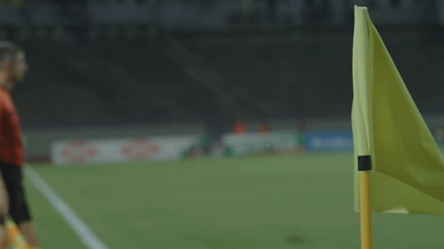 Assistant referee linesman moving along the sideline during a soccer match, 4k