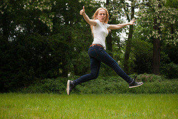Woman jumping, ok sign.