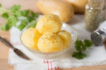 Boiled potato with oregano and salt on glass bowl.
