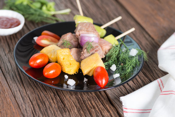 Bbq meat on sticks, kebab skewers with sauce, on wooden background. Traditional barbecue grill food.