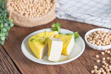 Yellow tofu sliced on plate with soy bean.