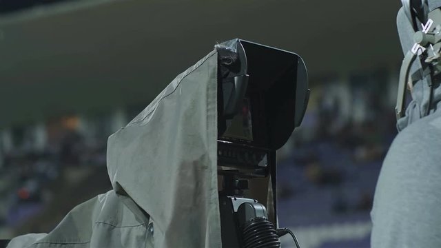 A professional cameraman with a camera during a soccer football TV broadcast at the stadium