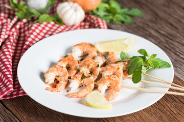 Fototapeta na wymiar Grilled shrimp skewers served on plate.