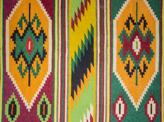 Close up of geometric patterned carpet. Hand woven rug with red, yellow, blue and other colors....
