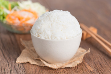 Fototapeta na wymiar White rice in bowl with chopsticks on table.