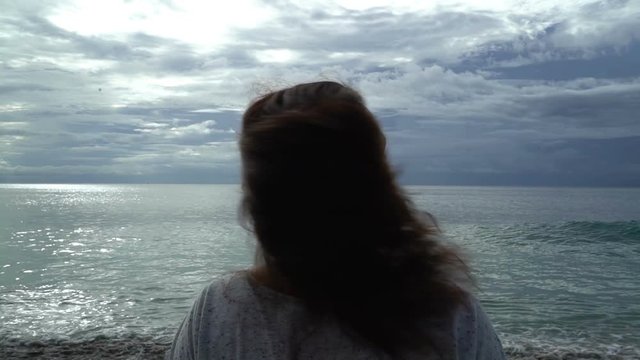 woman on beach sunset letting her hair down release from pin, freedom holidays concept