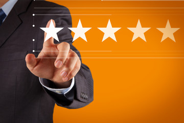 Five stars (5) rating with a businessman is touching virtual computer screen.For positive customer...