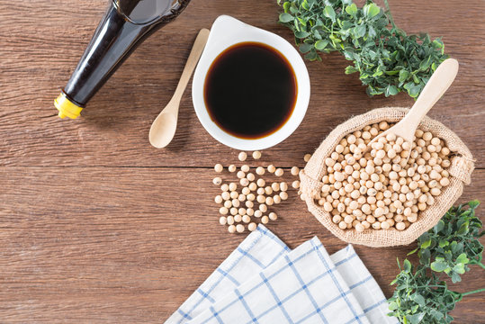 Soy bean with Soy sauce in bowl and bottle on wood background.