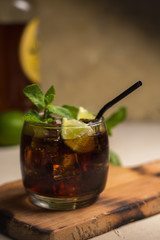 Cuba Libre drink with mint leaves and pieces of lime.