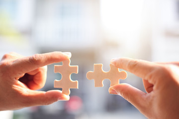 Closeup hand of a man connecting jigsaw puzzle with sunlight effect, Business solutions, success...