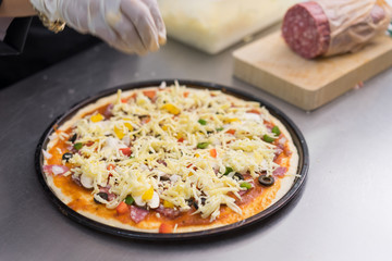 chef making pizza at kitchen