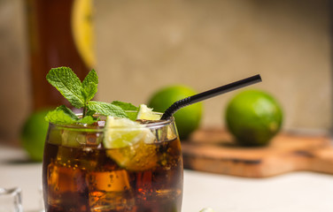 Cuba Libre drink with mint leaves and pieces of lime.