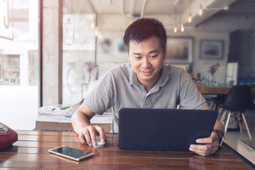 Young man use of the laptop computer in cafe.