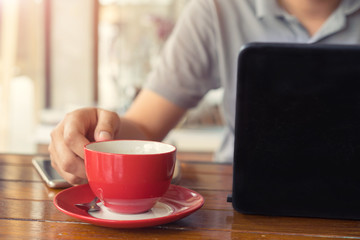 Man drinking hot coffee in cafe and working.