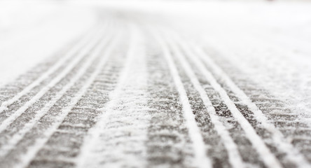 Wheel tracks on the road covered with snow - obrazy, fototapety, plakaty