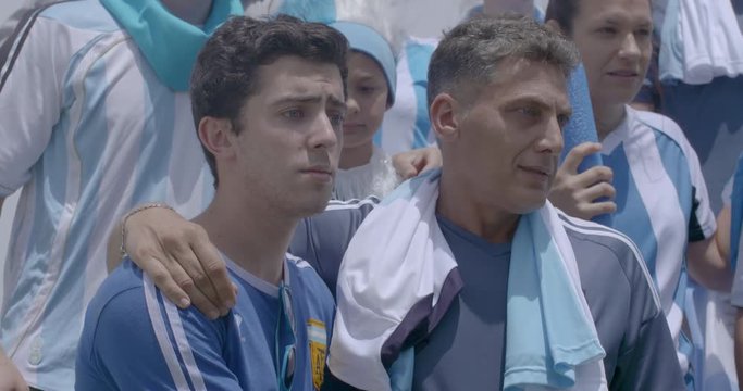 Argentinian football fans celebrating victory at match, slow motion