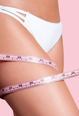 Diet concept, woman measuring her leg with a measure tape