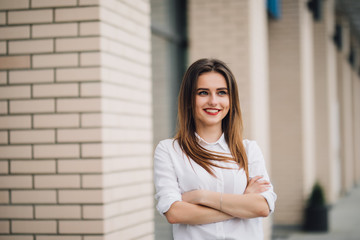 Fototapeta premium Confident woman looking at the camera while standing on the street with crossed hands