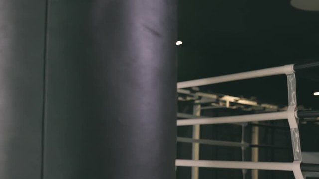 Young woman in boxing gloves hitting a boxing bag
